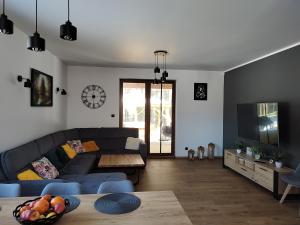 a living room with a couch and a table at Dom Przy Lesie na Warmii in Woryty