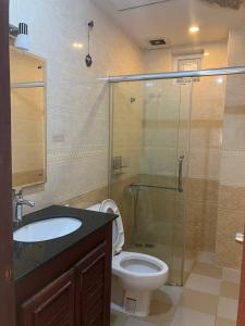 een badkamer met een toilet en een glazen douche bij Murrayrata in Phnom Penh
