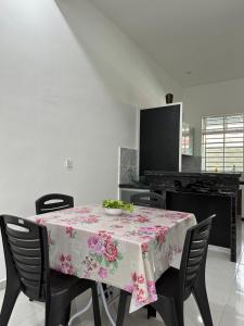uma mesa de jantar com uma toalha de mesa floral em Suri Kayangan em Arau
