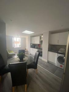 a living room with a table and chairs and a kitchen at Modern and Cosy 1-Bed Apt in the Heart of Dublin in Dublin