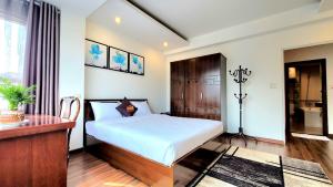 - une chambre avec un lit, un bureau et une table dans l'établissement Red Building - Hotel - Hà Nội, à Hanoï