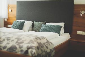 A bed or beds in a room at Weingut & Gästehaus zum Seeblick - Familie Sattler