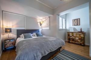 a bedroom with a large bed with blue pillows at Sé Apartamento - Casa do Chafariz in Braga