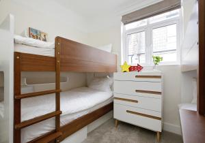ロンドンにあるFabulous Hyde Park Mews Apartment London w2 MEWSの小さなベッドルーム(二段ベッド1組、ドレッサー付)