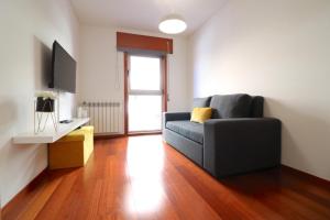 uma sala de estar com um sofá e uma televisão em Sé Apartamentos - Cruz de Pedra Apartment em Braga