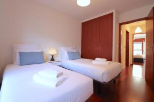 two beds sitting next to each other in a room at Sé Apartamentos - Cruz de Pedra Apartment in Braga