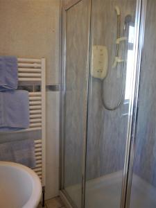 a bathroom with a shower and a sink at Woodhall Cottage in Annan