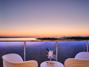 einen Balkon mit einem Tisch und Stühlen bei Sonnenuntergang in der Unterkunft Five Flowers Hotel & Spa Formentera in Es Pujols