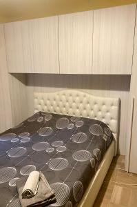 1 dormitorio con 1 cama con manta blanca y negra en Villa Zara, en Siena