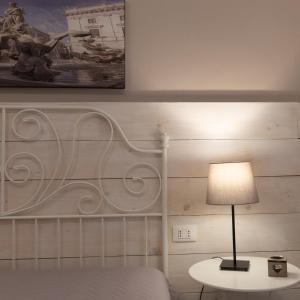 a bedroom with a bed and a table with a lamp at SyracuseApartments IL PIAVE di SIRACUSA Appartamento per 6 persone vicino ad ORTIGIA a 200m dal MARE in Syracuse