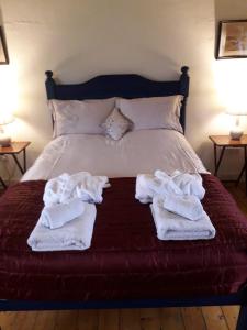 a bed with towels on top of it at Duleep Singh Barn in Botesdale