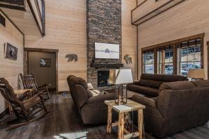 a living room with leather furniture and a fireplace at Staycation Lodge with Indoor Pool and Basketball Court in Branson