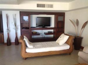 a living room with a wicker chair and a television at Bay view grand residencial - 3 beds-501 in Ixtapa