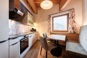 eine Küche mit einem Tisch und einem Fenster in der Unterkunft Hotel Garni Feuerstein in Sankt Anton am Arlberg