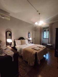 um quarto com uma cama grande, uma mesa e 2 candeeiros em Hotel Boavista - Vintage House em Monfortinho