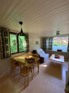 un salon avec une table et un canapé dans l'établissement Cottage Rosa, à Tourtoirac