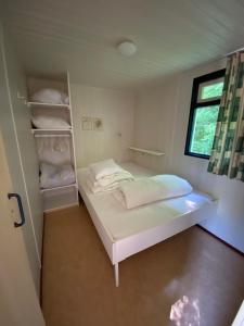 une petite chambre avec un lit et une fenêtre dans l'établissement Cottage Rosa, à Tourtoirac