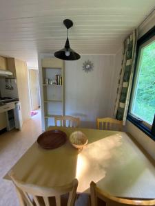 une table à manger et des chaises dans une cuisine avec une fenêtre dans l'établissement Cottage Rosa, à Tourtoirac