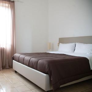 um quarto com uma cama grande e um cobertor castanho em Bed and Breakfast Villa Alba em Controguerra