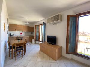 a kitchen and dining room with a table and a television at SAGGI - 3 posti letto sul mare con posto auto in San Vincenzo