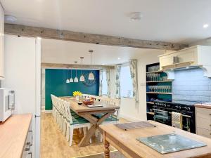 a kitchen with a wooden table in a room at Mark Close Farmhouse in Alston