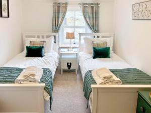 艾斯頓的住宿－馬克勞斯度假屋，带窗户的客房内设有两张单人床。