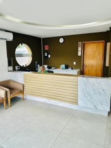 a woman sitting at a counter in a waiting room at Porto Smeralda Guarajuba C001 in Guarajuba