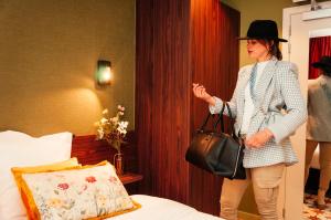 a woman is standing in a hotel room at Gran Hotel De Passage in Bruges