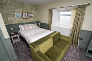 a bedroom with a bed and a window and a chair at Ardencaple Hotel by Greene King Inns in Rhu