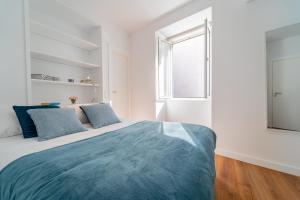 1 dormitorio blanco con 1 cama grande con almohadas azules en Praça Velha I, en Braga