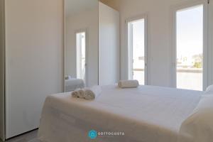 a bedroom with a bed with two towels on it at MADREPERLA - SAN FOCA in San Foca