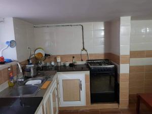 a small kitchen with a sink and a stove at Cirta duplexe in Constantine