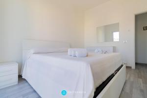 a white bed with white sheets and towels on it at MADREPERLA - SAN FOCA in San Foca +19 photos
