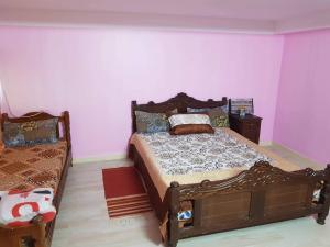 ein Schlafzimmer mit einem Bett in einem Zimmer mit rosa Wänden in der Unterkunft Cirta duplexe in Constantine