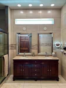 baño con 2 lavabos y espejo grande en Casa de campo con vistas espectaculares en Nogales