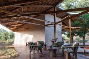 - une terrasse en bois avec des chaises et des tables sous un pavillon dans l'établissement Maison Etoile, à Dakar