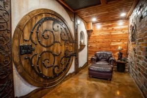 a large wooden door with a leather chair in a room at The Hobbit House, Fantasy comes Home! in Russellville