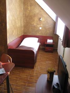 a small bedroom with a bed and a table and a tv at Motel Górno in Górno