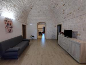 a living room with a couch and a tv at La casa di pietra in Monopoli