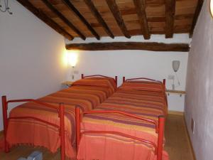 a row of four beds in a room at Appartamenti Piombino Isola d'Elba in Rio Marina