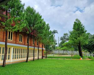 une rangée d'arbres devant un bâtiment dans l'établissement Asyana Sentul Bogor, à Bogor