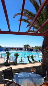 卡萊塔德菲斯泰的住宿－Sun beach Caleta 24，享有带桌椅的游泳池的景色