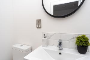 a bathroom with a sink and a mirror on the wall at Bishops Lynn House Apartments - Town Centre in King's Lynn