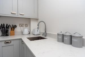 a kitchen with a sink and two trash cans at Bishops Lynn House Apartments - Town Centre in Kings Lynn