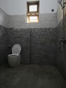 a bathroom with a toilet and a window at Wood Land Villa in Ambalantota