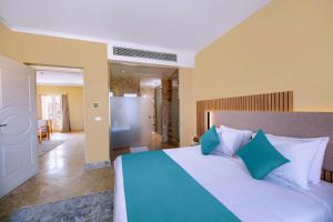 a bedroom with a bed with blue and white pillows at Zen Resort Sahl Hasheesh by TBH Hotels in Hurghada +36 photos