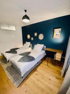 a bedroom with two beds and a blue wall at Loft66 avec parking privé in Clermont-Ferrand