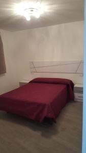a bedroom with a red bed in a room at CASA BALUARTE in Conil de la Frontera