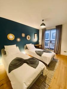 a bedroom with two beds with a bow tie on them at Loft66 avec parking privé in Clermont-Ferrand