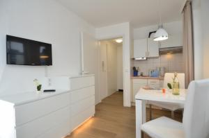 una cucina con armadi bianchi e tavolo bianco di Seepark Sellin - Apt. 371 a Ostseebad Sellin
